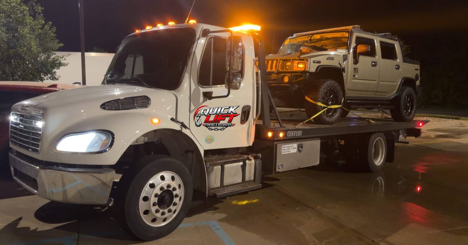 Quick Lift tow truck hauling an SUV on a night recovery call